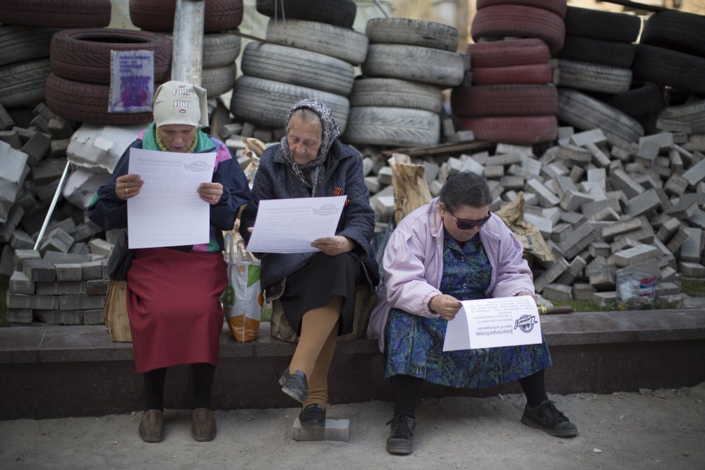 Women read a leaflet distributed by pro-Russian activists behind barricades near a regional administration building that was seized by pro-Russian activists earlier in Donetsk, Ukraine, on Wednesday.