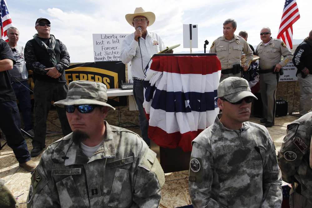 Rancher Cliven Bundy, center, addresses his supporters alongside Clark County Sheriff Doug Gillespie, right, on April 12. Bundy informed the public that the BLM had agreed to cease the roundup of his family’s cattle.