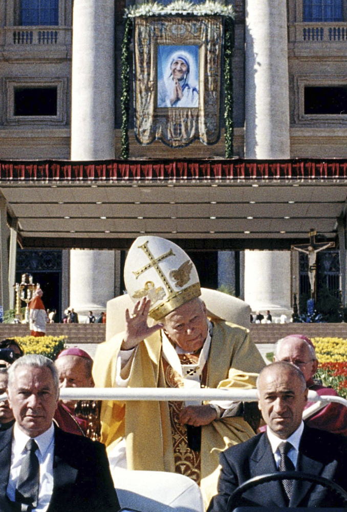 Pope John Paul II in his popemobile waves to the crowd as he leaves St. Peter’s Square after the beatification ceremony of Mother Teresa of Calcutta, depicted in a tapestry hung on the Basilica’s facade, at the Vatican. John Paul II declared more saints – 482 – than all his predecessors combined, considering them role models for a church desperately in need of them.
