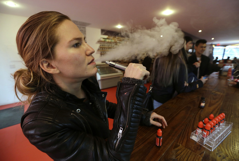 Talia Eisenberg, co-founder of the Henley Vaporium, uses her vaping device in New York on Feb. 20. Soon, the Food and Drug Administration will propose rules for e-cigarettes. The rules will likely have big implications for a fast-growing industry and its legions of customers.