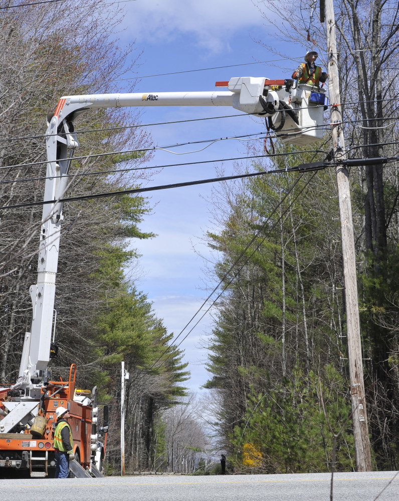 Central Maine Power linemen Shannon Trivett and Tim Laney, in the bucket, repair a downed power line on Maine Avenue in Standish on Thursday.
