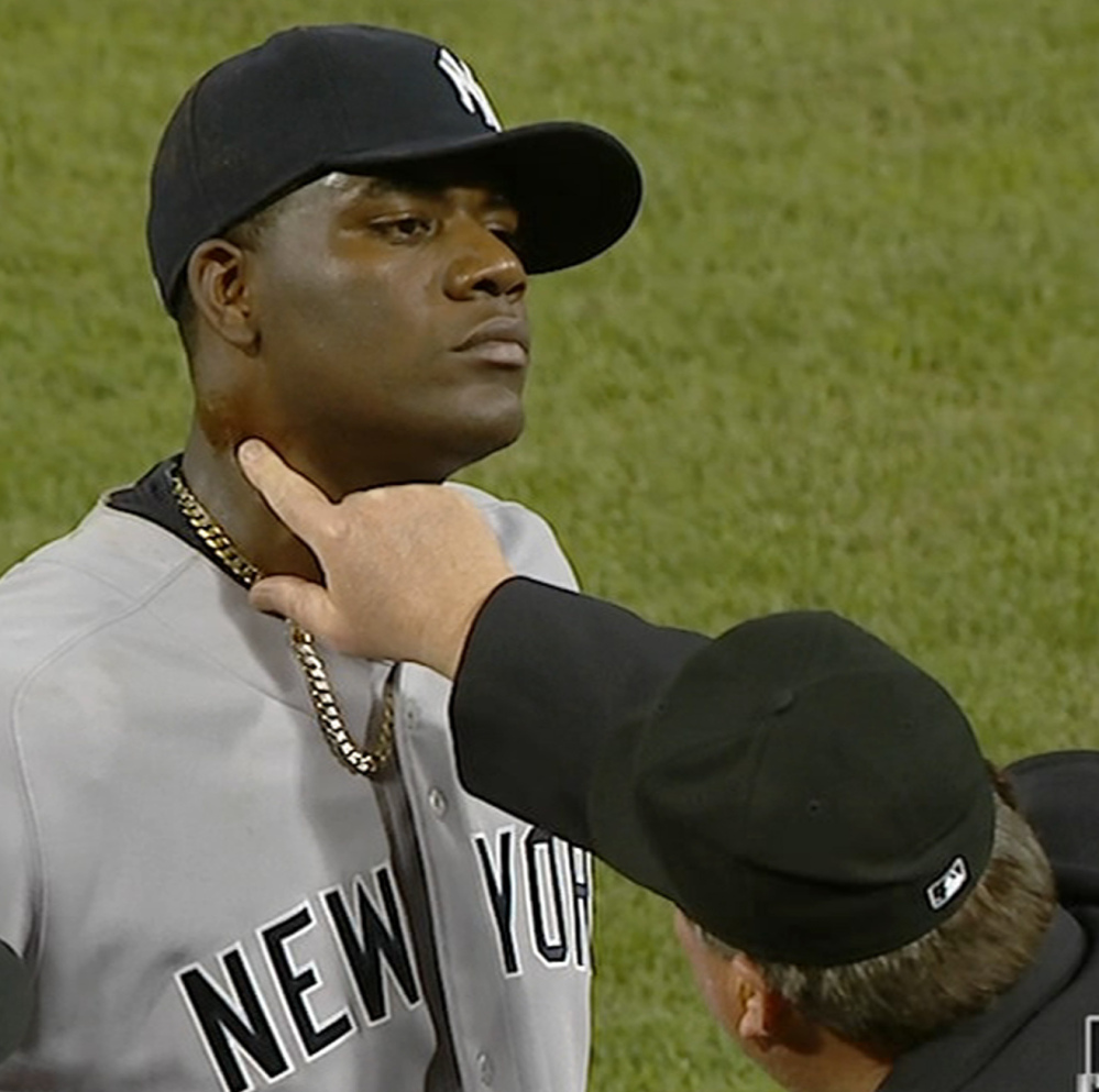 An umpire finds pine tar on Yankees pitcher Michael Pineda’s neck just before ejecting him from the game Wednesday.