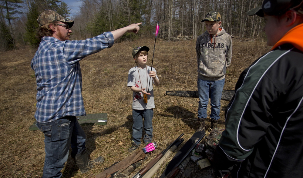 Travis McLeod of Halifax, Nova Scotia, shows Brady Whitman, 9, of Halifax how to balance an arrow on his fingertip during a youth turkey-hunting camp held at Point Sebago Resort in Casco.