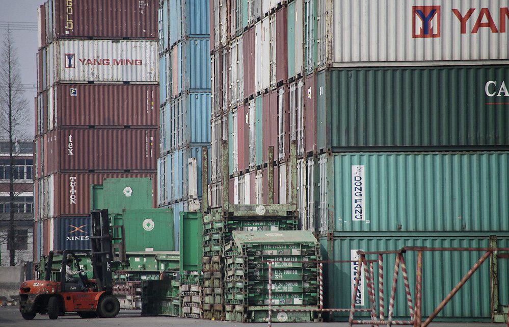 A forklift arranges shipping containers near a port in Shanghai in 2011. U.S. manufacturers have grown more competitive over the past decade compared with factories in China, Brazil and most of the world’s other major economies.