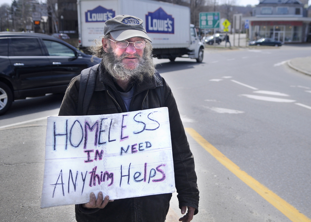Lloyd Bowden, 55, panhandles Friday at Memorial Circle in Augusta. Bowden said he is living in the basement of a relative’s house in Augusta until he can buy a tent. He said the money people give him goes “all to food.”