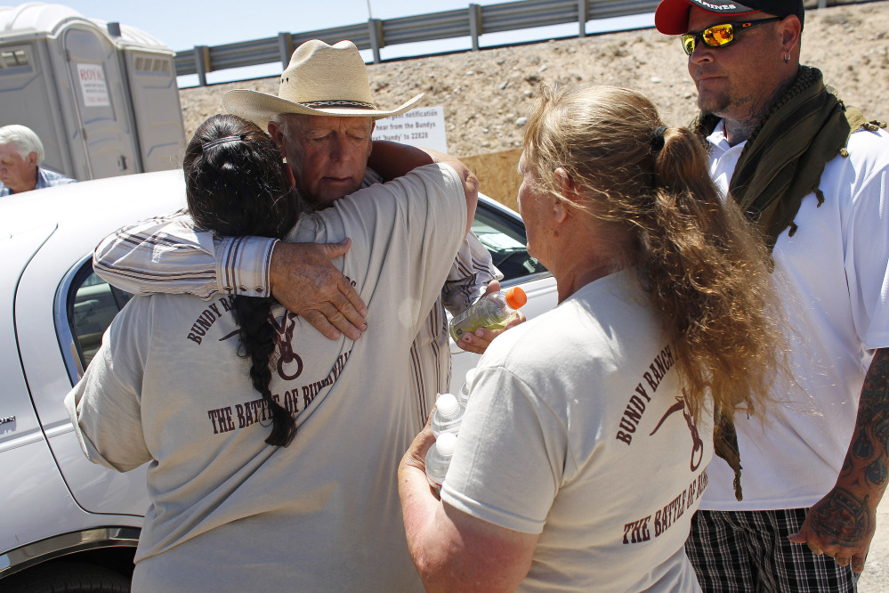 Rancher Cliven Bundy, second from left, hugs a supporter before holding a news conference near Bunkerville, Nev., on Thursday.