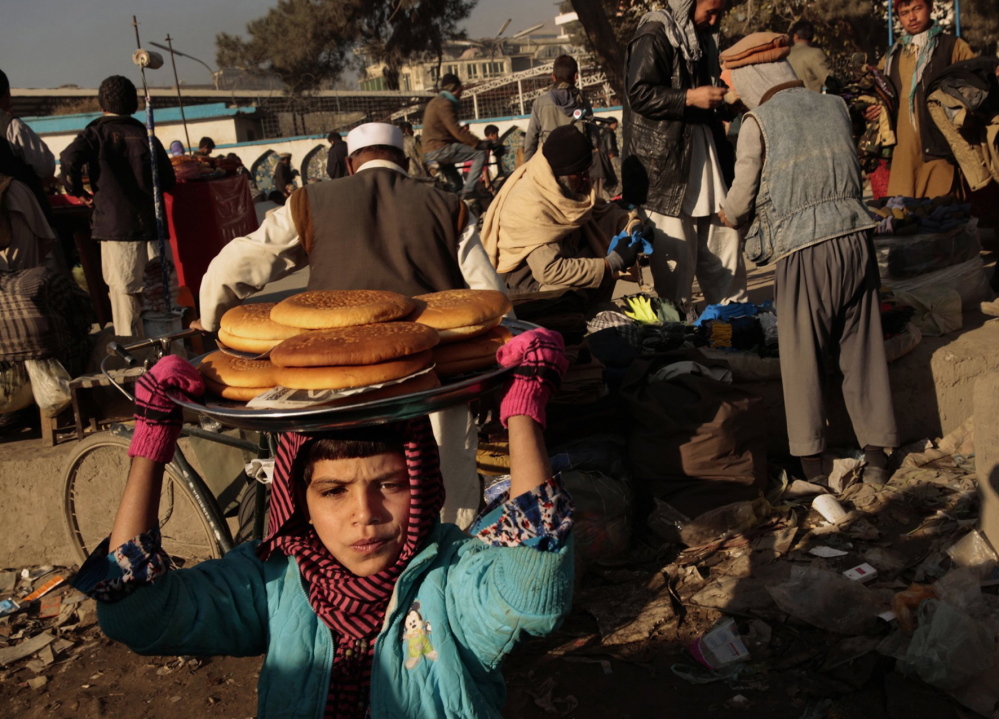 A young girl works selling bread in downtown Kabul. Child labor is pervasive in Afghanistan because of the need to have family members earning income.