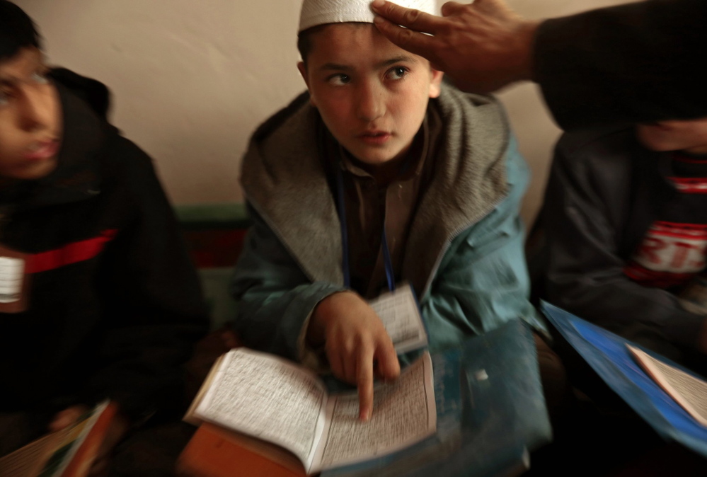 Sami Rahimi attends Islamic religious school classes for an hour each day. Rahimi, 13, lives and works in a bread bakery in Kabul, Afghanistan. He earns about $3 per day to help support his family, which lives in a northern province.