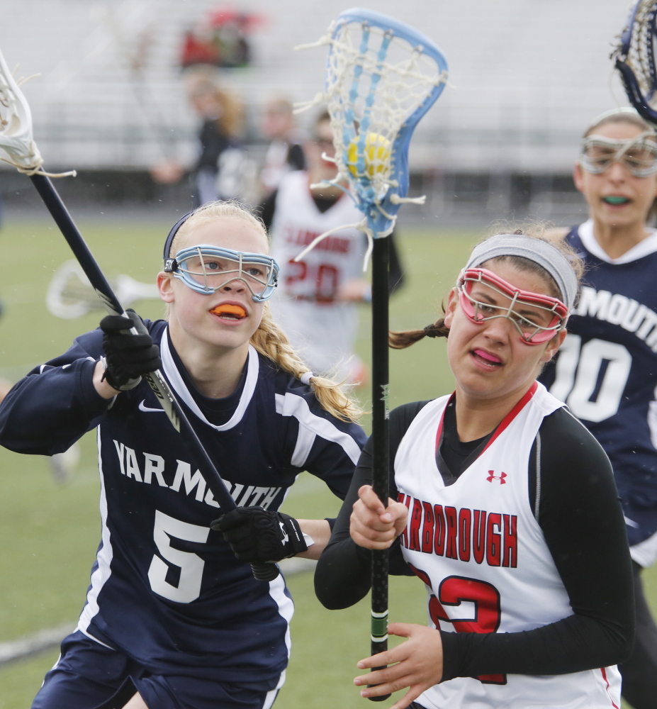 Emma Crovo, right, of Scarborough avoids a check by Eliza Lunt of Yarmouth during a girls’ lacrosse season opener Saturday in Scarborough. Scarborough won, 9-7.