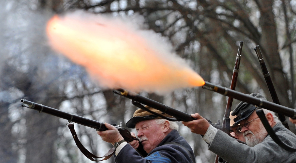 Civil War re-enactors of the Confederate Army’s 15th Alabama, Company G, perform a firing demonstration Saturday during a re-enactment at Abbott Park in Farmington.