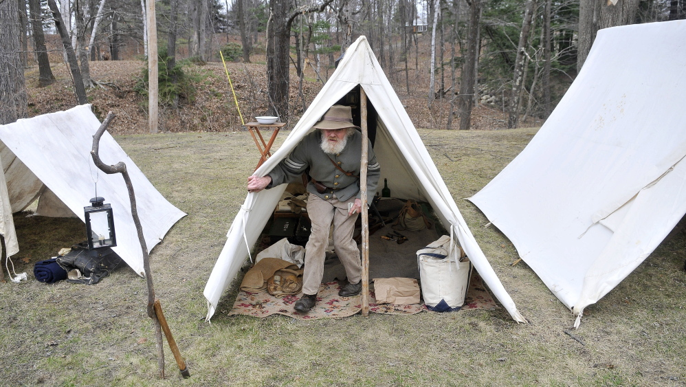 Tom Basford of Gardiner, acting as a corporal with the Confederate Army’s 15th Alabama, Company G, emerges from his tent Saturday at a Civil War camp at Abbott Park in Farmington.