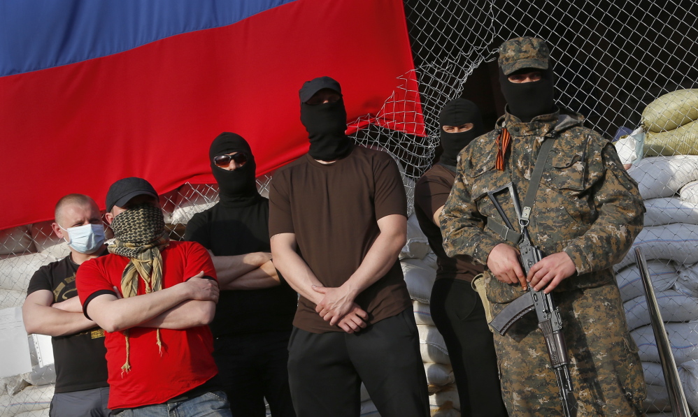 Masked pro-Russian armed men stand at city hall during negotiations about the release of foreign military observers being held by insurgents in Slovyansk, eastern Ukraine, on Sunday.