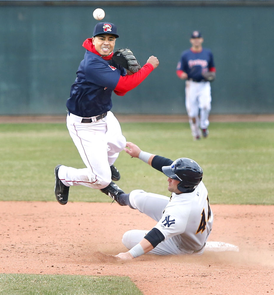 Sea Dogs second baseman Mookie Betts avoids Thunder first baseman Kyle Roller to turn a double play at Hadlock Field in Portland on Sunday.