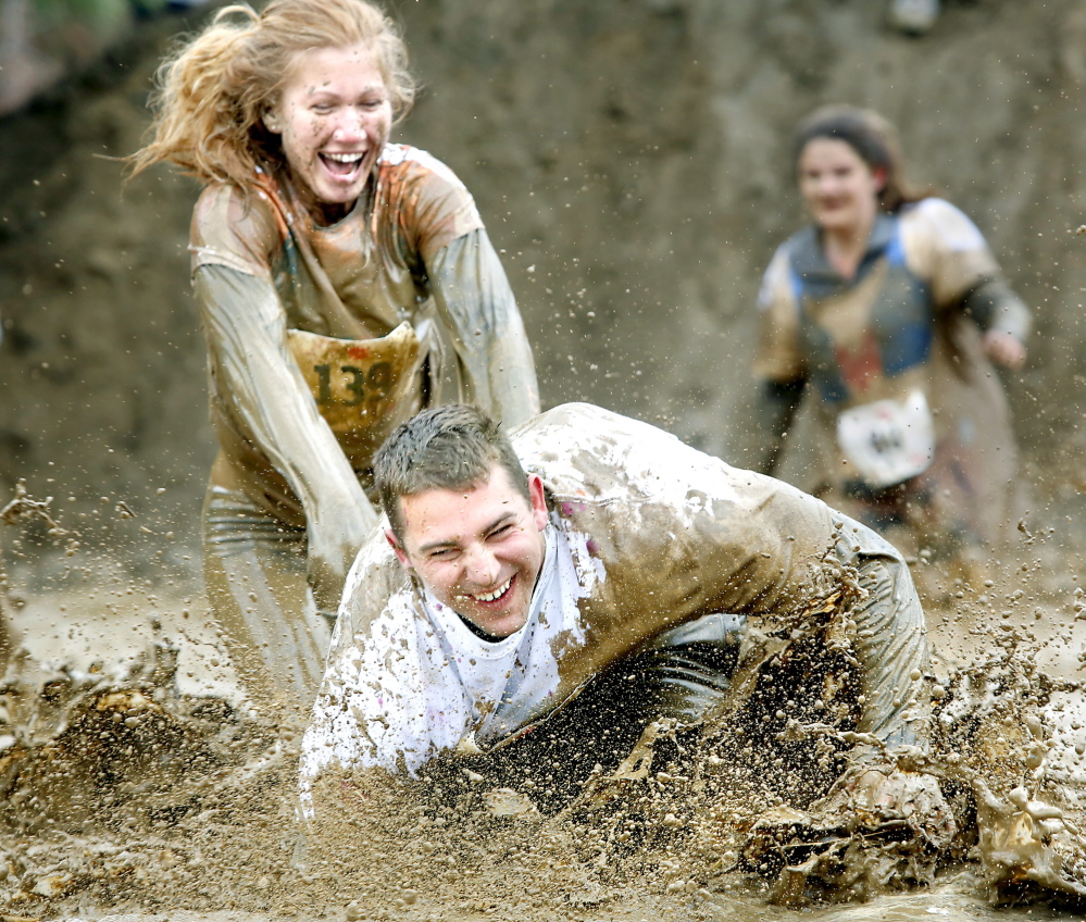 Melissa Laughlin makes sure Blake Laughlin gets the full experience of a mud pit Sunday during the Into the Mud Challenge. The 2.5-mile course at Gorham Middle School was dotted with mud and obstacles to challenge the nearly 1,000 racers.