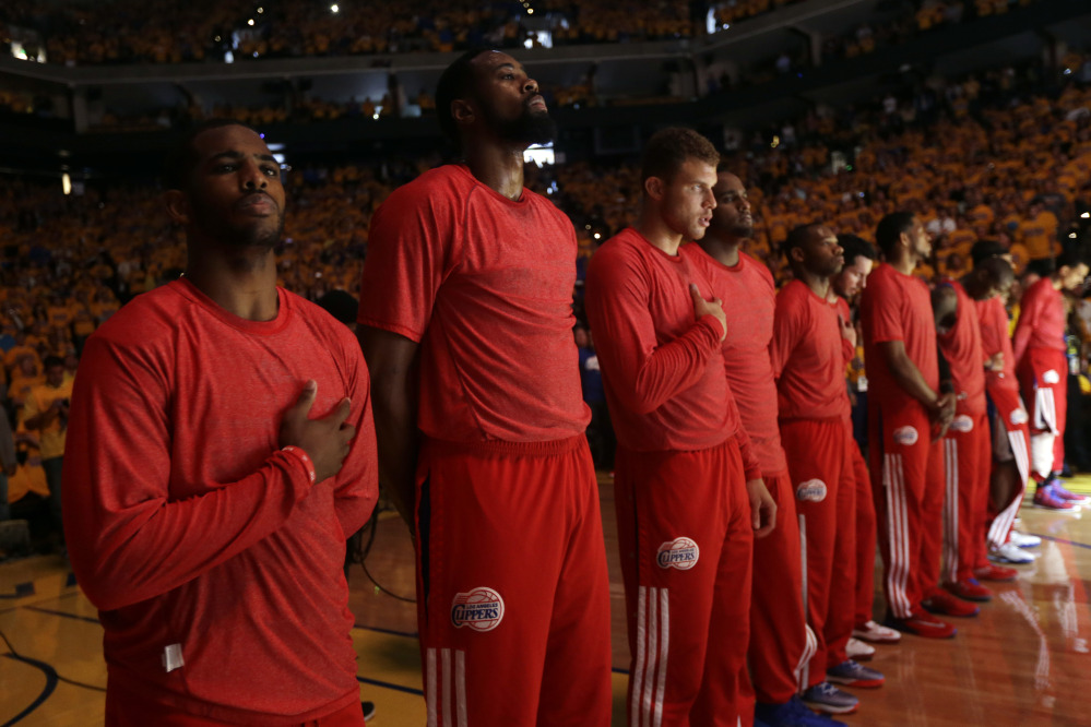 Members of the Los Angeles Clippers listen to the national anthem before Game 4 of an opening-round NBA basketball playoff series against the Golden State Warriors on Sunday.