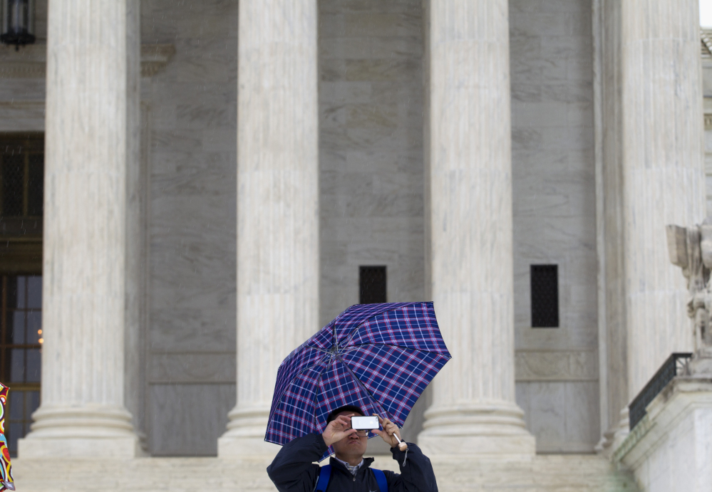 A man takes a picture Tuesday outside the U.S. Supreme Court, where justices were confronting the question of whether police need a warrant to search the cellphone of an arrested suspect.