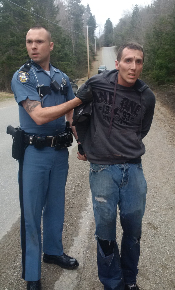 Trooper Tucker Bonnevie arrests burglary suspect Charles Fling of Brewer after tackling him as he ran through the woods in Dedham, following a high-speed chase Monday.