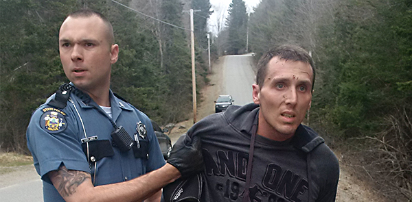 A Maine State Police officer takes Charles Fling, 33, of Brewer, into custody after a high-speed chase in Dedham.