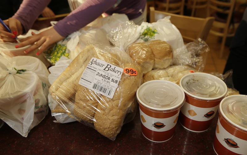 A volunteer labels food provided by the Yasmeen Bakery in Dearborn, Mich., Friday, April 25, 2014. The reach of one of the nation’s few charitable organizations exclusively providing halal food to the poor could be greatly expanded under the new federal provision.