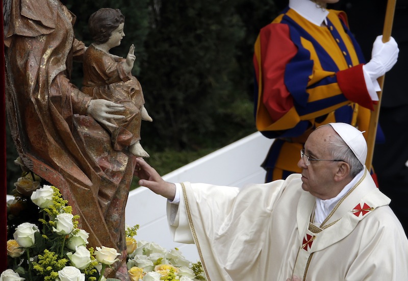 Pope Francis touches a statue of the Virgin Mary as he leads a solemn ceremony in St. Peter's Square at the Vatican on Sunday.