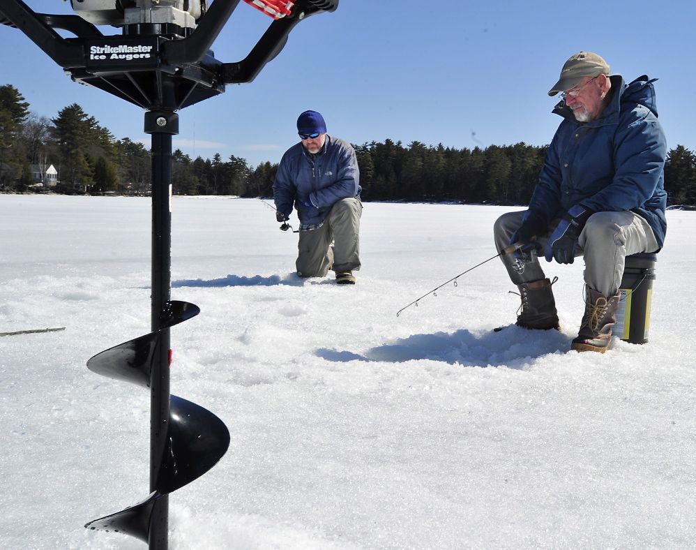 It's Opening Day for fishermen in the Naples area. but ice fishermen, like Roman Jozefiak of Scarborough, left, and Peter Brawn of Cape Elizabeth continue to ice fish on Sebago Lake Tuesday.