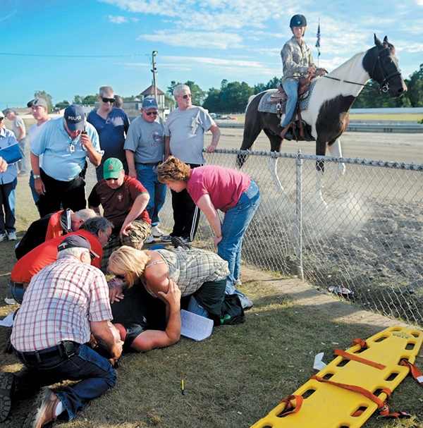 People attend to the injured who were struck by the racing gate at the start of the 13th race at the WIndsor Fair in this September 2010 photo. The gate, towed by a vehicle, hit five people watching the race.