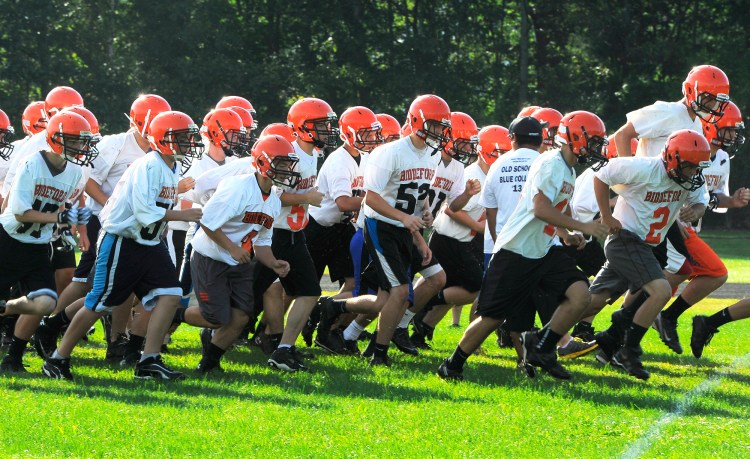 Sprints are part of the first day of football practice at Biddeford HS with coach Brian Curit. John Patriquin/Staff Photographer