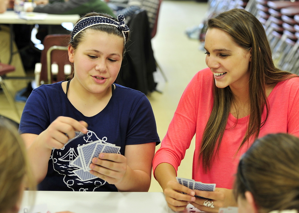 Westbrook High School sophomore Chelsea Rairdon, right, plays cards Wednesday with Abbigail Maxfield, 12, during a Big Brother-Big Sister session at the Westbrook Community Center. Rairdon is part of a student group trying to change attitudes about substance abuse at the school.