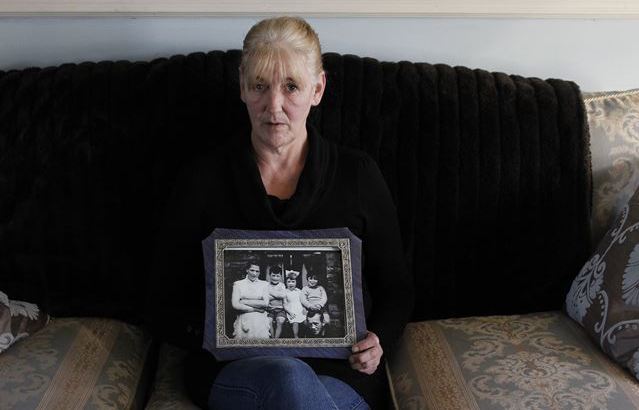 Helen McKendry, at home in Killyleagh, Northern Ireland, holds an old family photo that shows her mother, Jean McConville. Sinn Fein leader Gerry Adams has been arrested in connection with McConville’s slaying in 1972.