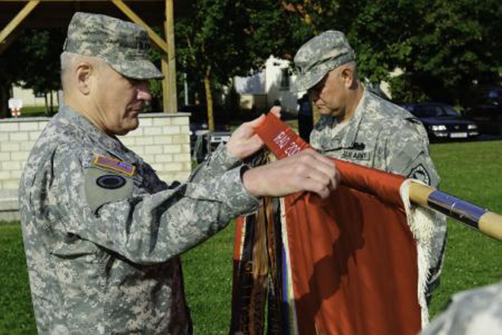 Gen. Carter Ham attaches a Meritorious Unit Commendation streamer to the colors of the Maine Army National Guard’s 133rd Engineer Battalion at a 2009 ceremony in Hohenfels, Germany. The 133rd is Maine’s oldest and largest military unit.