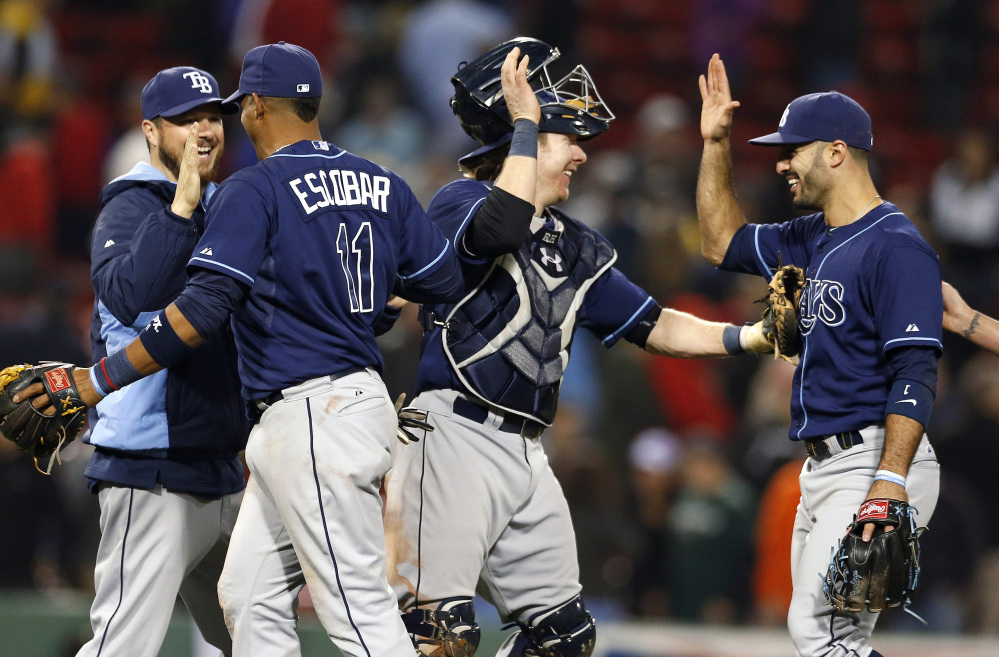 Tampa Bay Rays Yunel Escobar (11), Ryan Hanigan, second from right, and Sean Rodriguez, right, celebrate after defeating the Boston Red Sox 6-5 in the second game of a doubleheader in Boston on Thursday.