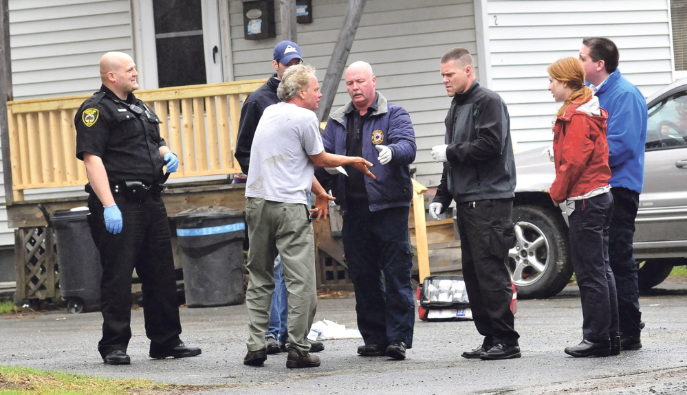 Winslow rescue and Delta Ambulance personnel treat a man whose hands and face were bloodied after he broke windows and damaged doors with a snow shovel at an apartment building at 92 Clinton Ave. in Winslow on Thursday. Winslow police officers Scott Christiansen, left, and Brandon Lund stand by.