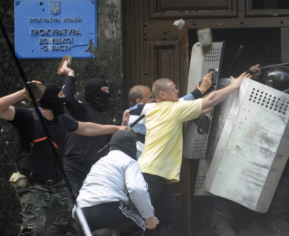 Pro-Russian activists try to wrestle shields from police in front of the regional administration building in Donetsk, Ukraine, on Thursday.