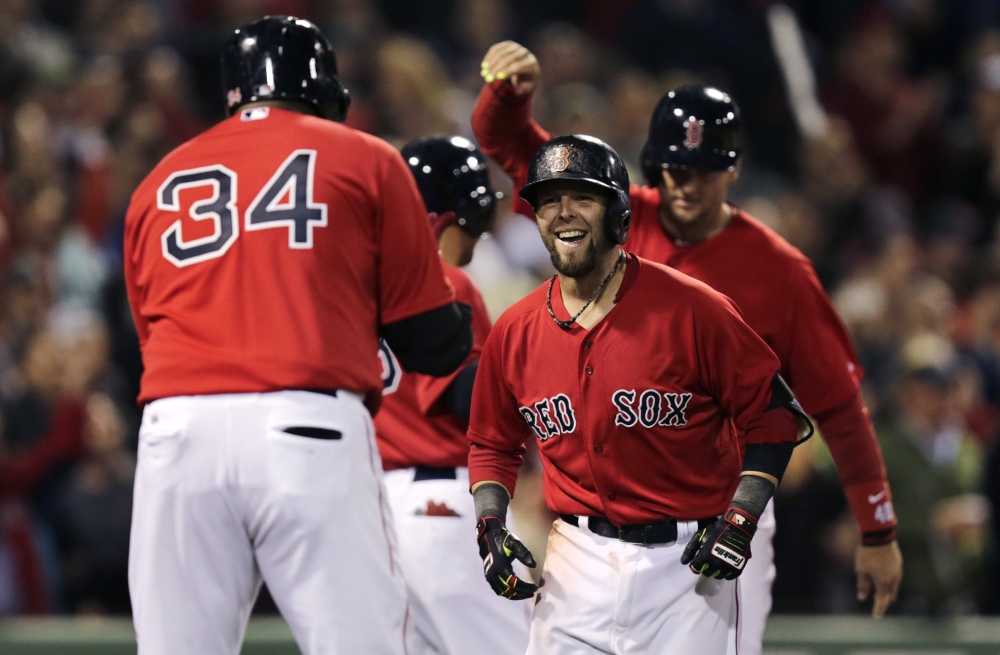 Red Sox second baseman Dustin Pedroia smiles as he is congratulated by teammate David Ortiz after his grand slam off Oakland Athletics pitcher Ryan Cook in the sixth inning at Fenway Park on Friday.
