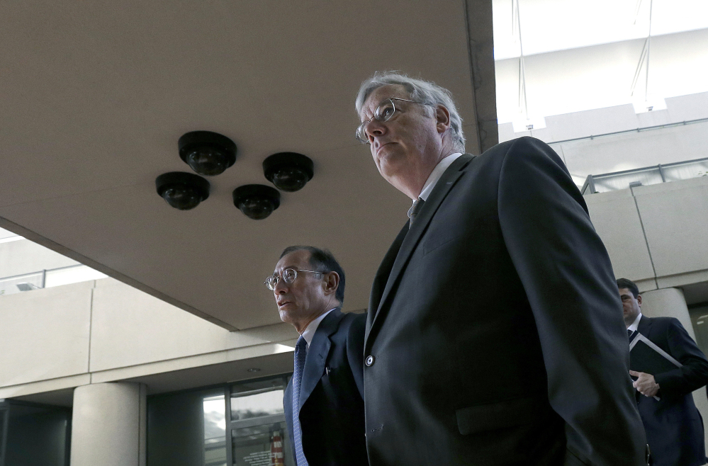 In this Tuesday, April 29, 2014, file photo, Apple attorneys Harold McElhinny, foreground, and William Lee walk to a federal courthouse in San Jose, Calif., Tuesday.