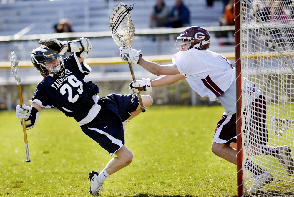 Brendan Dioli of Yarmouth is shoved away from the Greely net by goalkeeper Griffin Doree after Dioli unleashed a shot Friday during Yarmouth’s 9-5 victory at Cumberland. High school roundups, D3.