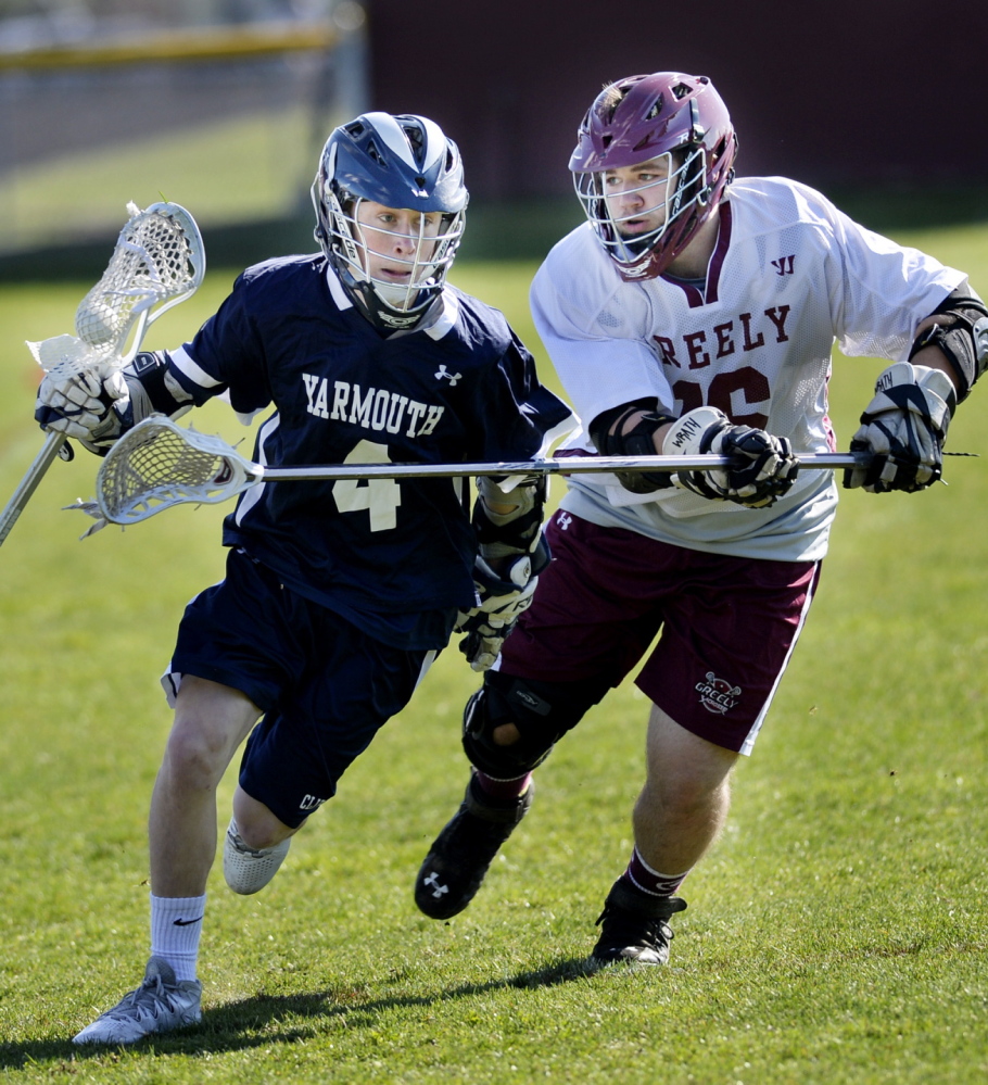 Patrick Grant of Yarmouth runs up the field with the ball Friday while being defended by Ryan Pomeroy of Greely during Yarmouth’s 9-5 victory in a boys’ lacrosse game at Cumberland.