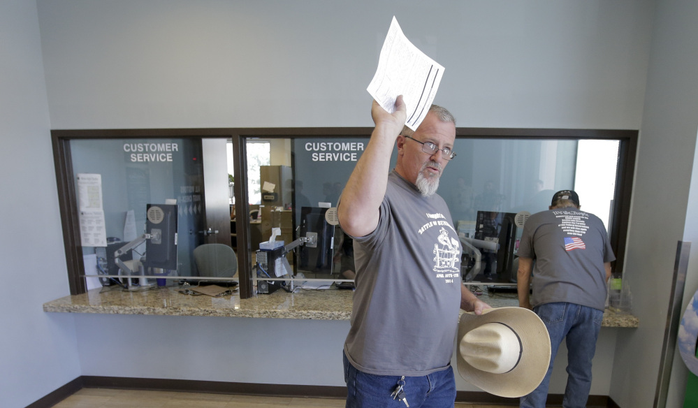 Sean Harron, a supporter of Cliven Bundy, waves after turning in a complaint against the Bureau of Land Management at the Metropolitan Police Department in Las Vegas on Friday.