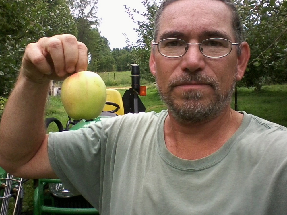 Mike Bendzela holds a heritage Chenango Strawberry apple.