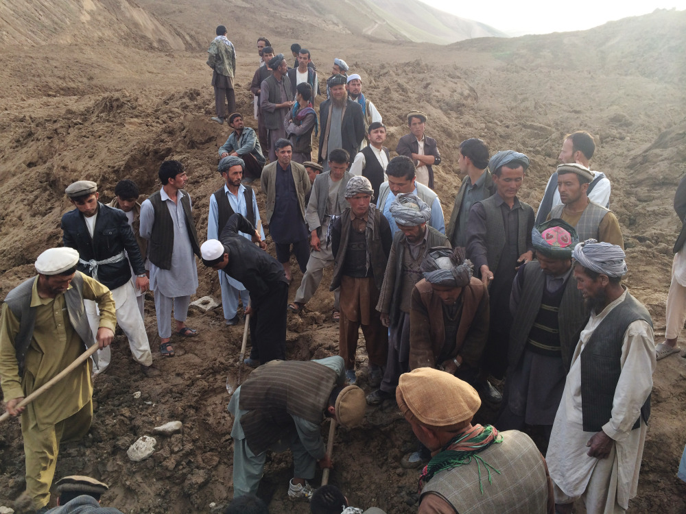 In this Friday, May 2, 2014 photo provided by Homayoon Rahmani, chief of road reconstruction program in the Afghan Rural and Rehabilitation Development Ministry, Afghans search for survivors buried after a massive landslide in a village in Badakshan province, northeastern Afghanistan.