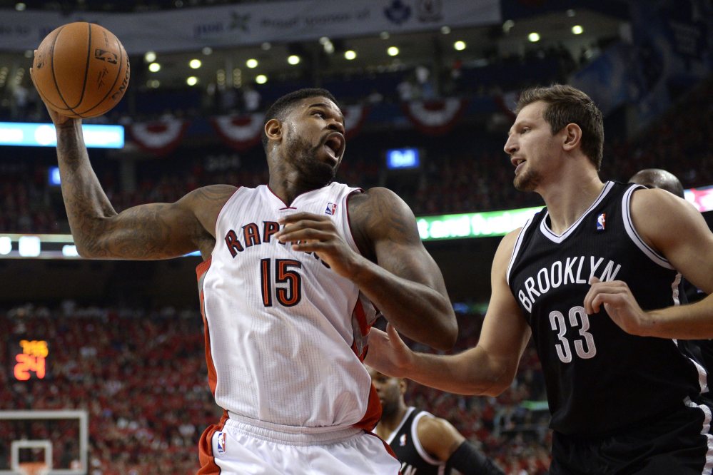 Toronto’s Amir Johnson, left, works against Brooklyn’s Mirza Teletovic in the first half of Game 7 at Toronto on Sunday. The Nets advanced with a 104-103 win.