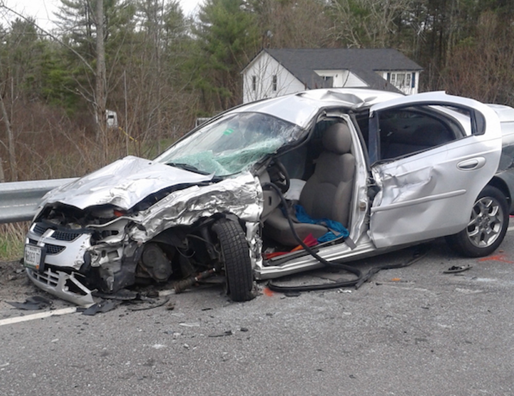 A woman is in satisfactory condition after a head-on crash in Newfield totaled this car. Police said a pickup driver bent over to pick up his cellphone just before the accident.