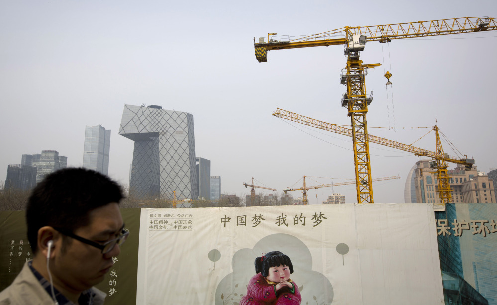 A man walks past a Chinese government propaganda billboard with the words “China Dream, Is My Dream” near a construction site in Beijing. China’s January-to-March growth slowed to 7.4 percent, its weakest quarter since the 2008-2009 global crisis, but that would still qualify as explosive for most of the world’s economies.