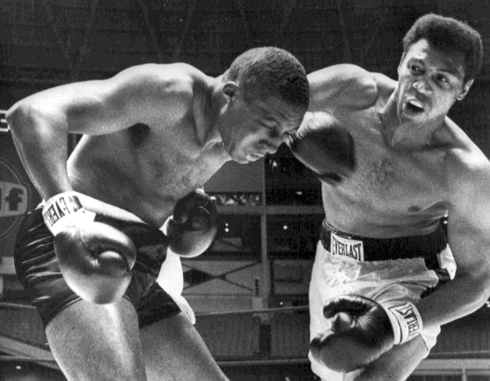 Jimmy Ellis, right, delivers a right hook to the head of Leotis Martin during their 12-round World Heavyweight title elimination fight in Houston, Texas. Ellis, who won the 1968 championship, died Tuesday. He had suffered from dementia for more than a decade.