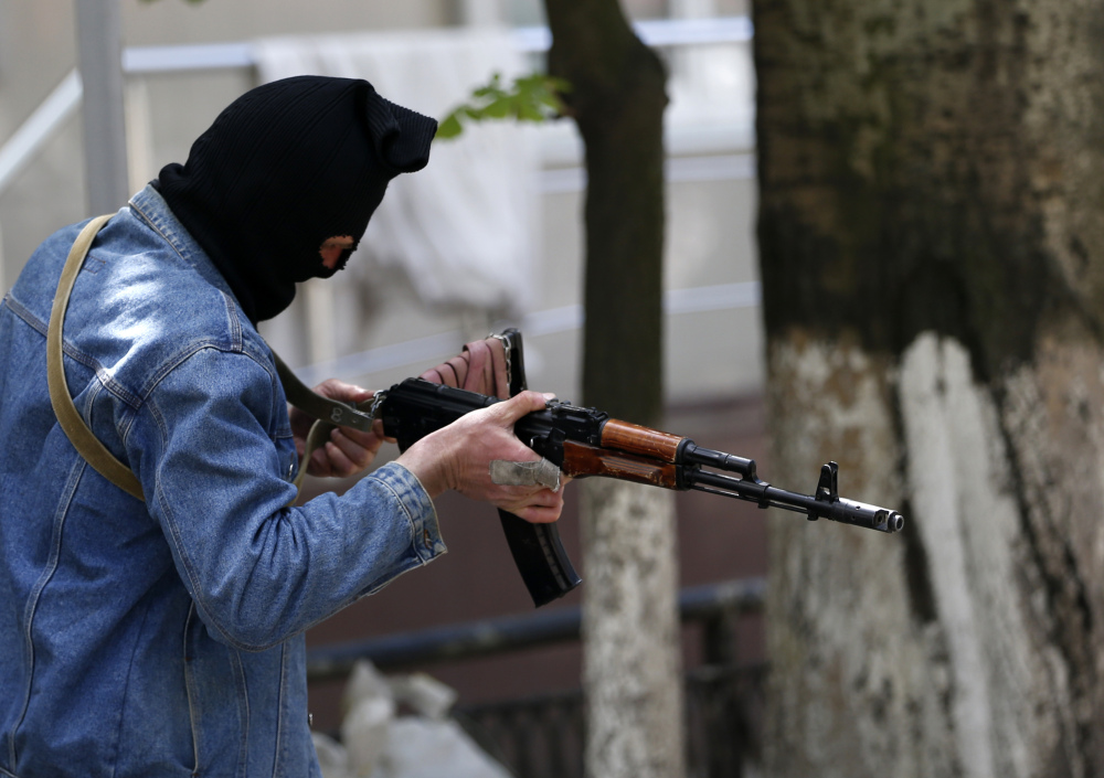 A pro-Russian gunman holds his weapon while guarding the local administration building in the center of Slovyansk, eastern Ukraine, Tuesday.