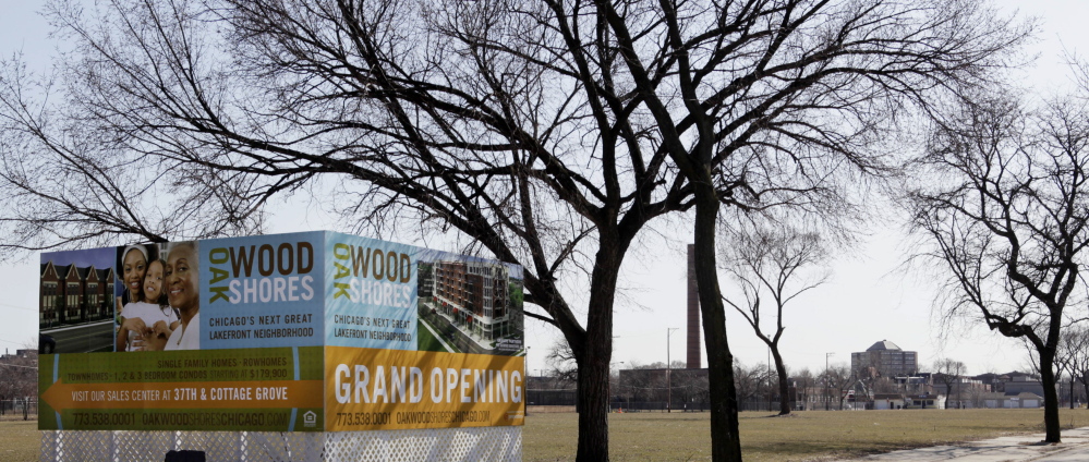 A corner billboard sits in a vacant lot, advertising where a variety of housing will be built in Chicago.