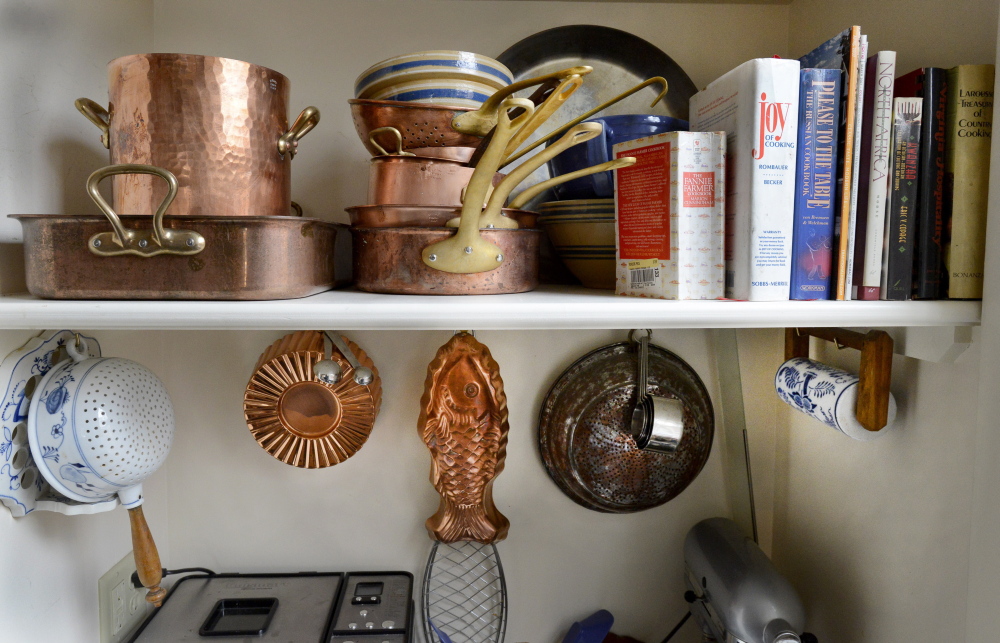 Kitchen implements and cookbooks line the shelves.