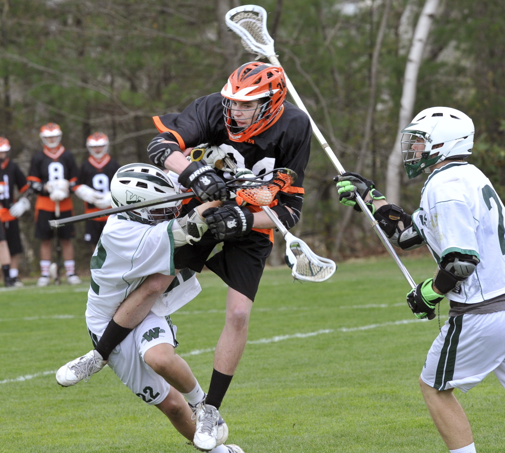 Brad McLellan of North Yarmouth Academy is checked by Cooper Chap of Waynflete as Reilly Musgrave moves in Tuesday during Waynflete’s 6-4 victory in a boys’ lacrosse game at Fore River Fields in Portland.