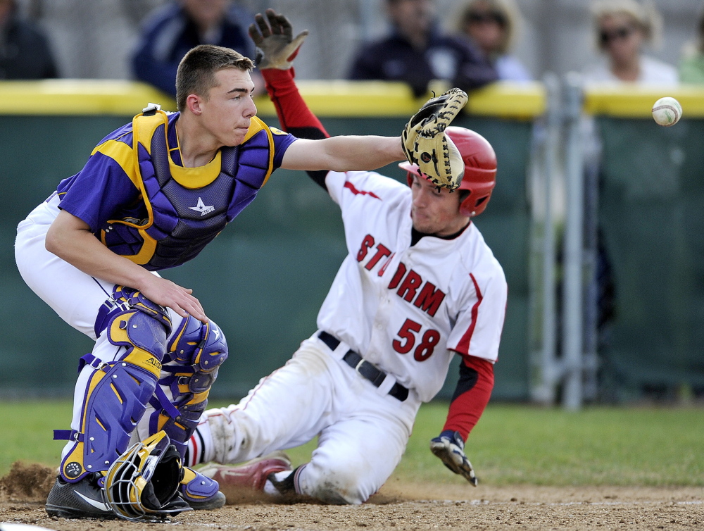 Cheverus catcher Logan McCarthy takes a late throw as Zach Carreiro of Scarborough slides safely home, scoring on a Ben Greenberg single in the third inning Tuesday during a 2-0 victory. The win is the Red Storm’s first of the year.