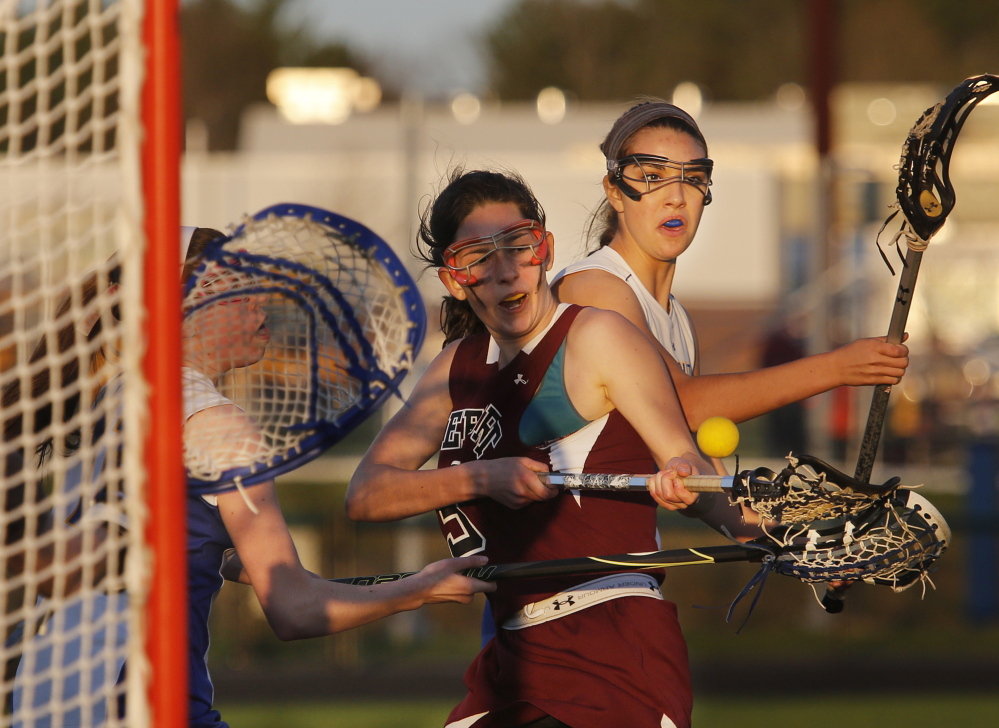 Olivia Stucker of Falmouth, left, denies a shot attempt by Lizzie Martin of Freeport during their girls’ lacrosse game Wednesday. Martin scored two goals as the Falcons came away with an 8-7 victory.
